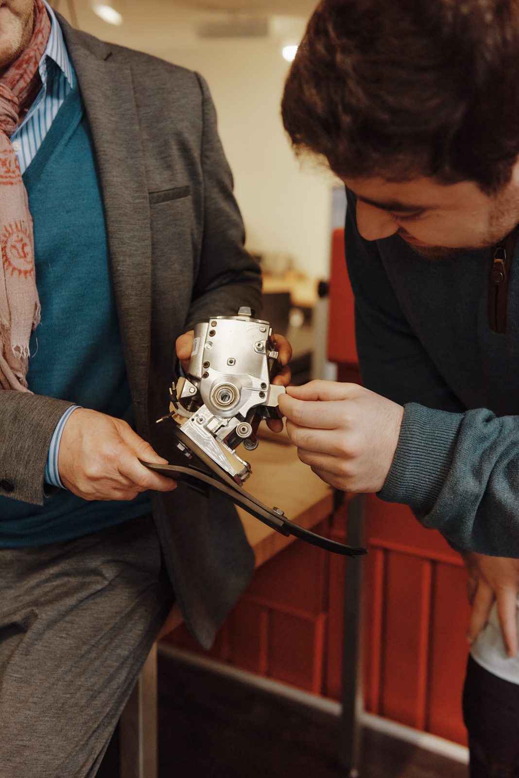 Closeup shot of Hugh Herr and Christopher Shallal holding one of the bionic devices they are working on.